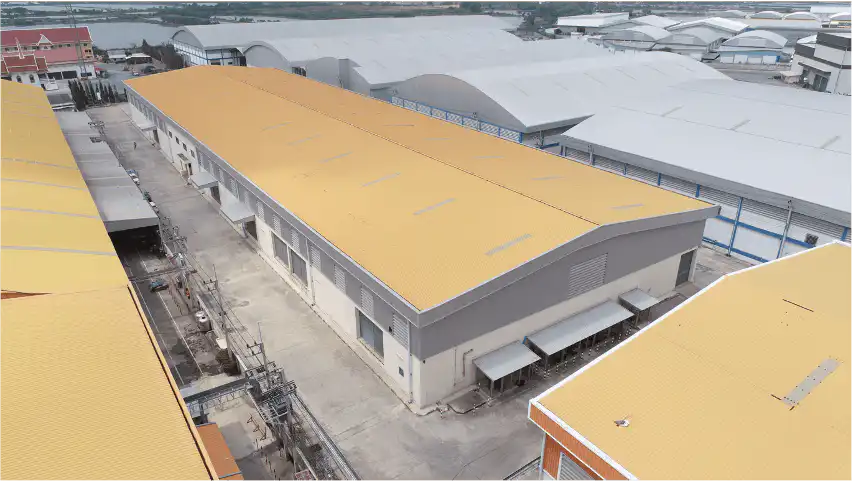 Premium Warehouse @BANGBO aerial view. Large industrial building with yellow roof and gray exterior.