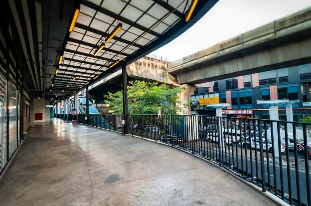 Summer Hill Sukhumvit's elevated walkway with a view of Texas Chicken restaurant and the city street below.