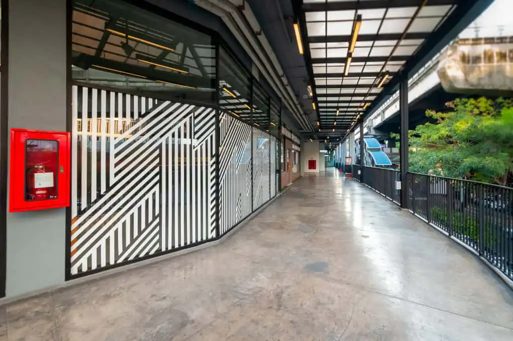 Summer Hill (Sukhumvit) walkway with modern black and white design, fire extinguisher, and overhead lighting.