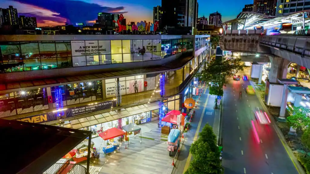 Summer Hill Sukhumvit at night, Bangkok. Features shops, offices and elevated train tracks.